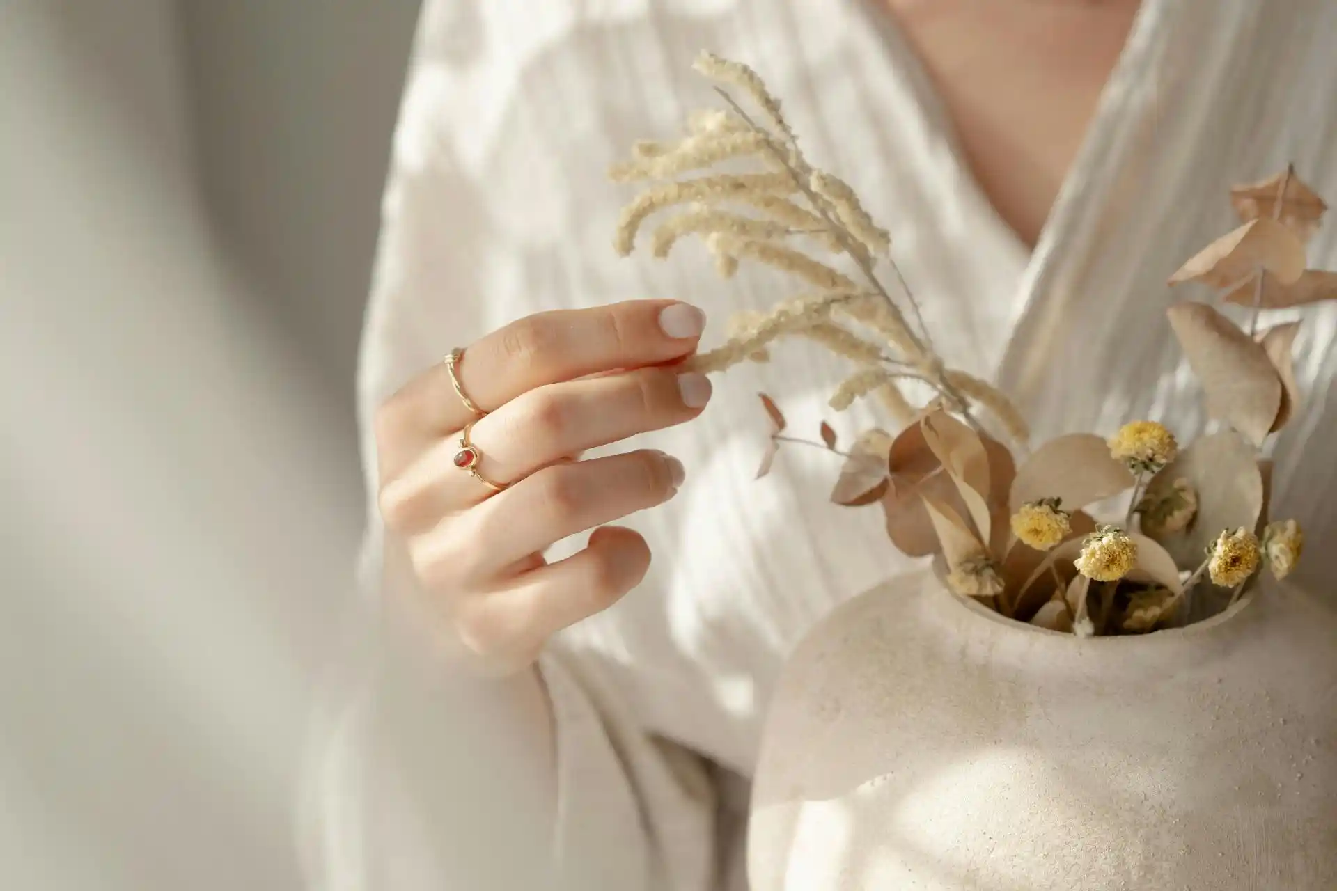 Woman’s hand touching plants, representing connection to nature and the Ayurvedic dosha test.
